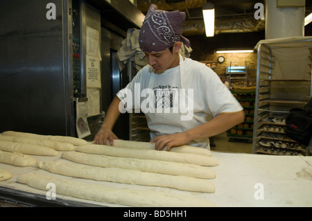 Workers at Amy s Bread in Chelsea Market in New York bake loaves of bread in the bakery s commercial ovens Stock Photo