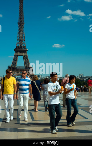 Paris France, Medium Crowd People, Street Scene, Tourist Couples, One Asian Couple, Boys Eating Ice Cream, Walking near the Eiffel Tower Stock Photo