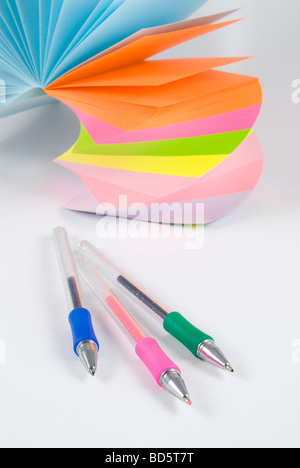 Colorful postit sticky notes with three colorful ballpens studio isolated on white background Stock Photo