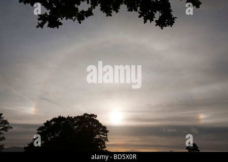 A rainbow around the sun caused by refraction from ice crystals in high level cloud Stock Photo