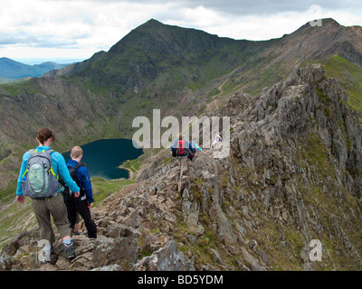 Walking along the knife edge ridge between Crib Goch and Mount Snowdon, North Wales. Stock Photo