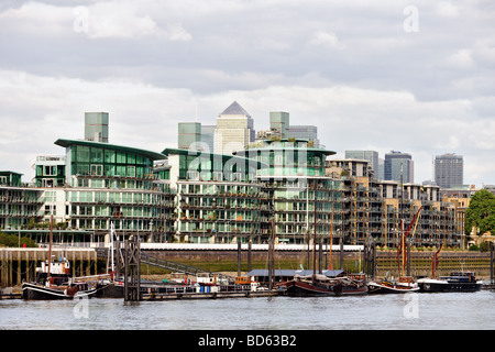 Typical private Thames riverside apartments Wapping East End London England UK, with Canary Wharf in the background Stock Photo
