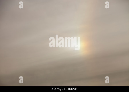 A rainbow around the sun caused by refraction from ice crystals in high level cloud Stock Photo
