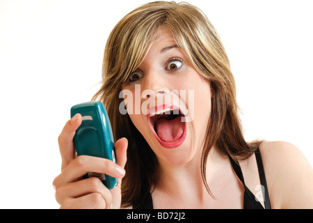 Young woman screaming while holding a cellphone in her hand Stock Photo