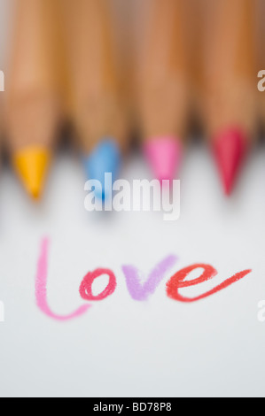Coloured love word on paper and colouring pencils Stock Photo