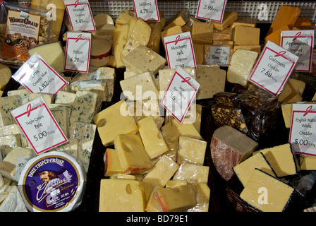 Delicatessen specialty imported cheeses in open stainless steel display case Stock Photo