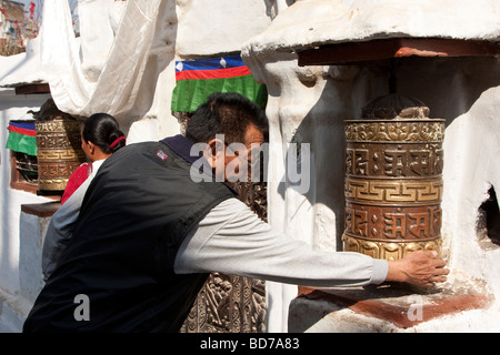 Bodhnath, Nepal.  Buddhist Worshiper Turning Prayer Wheel. Stock Photo