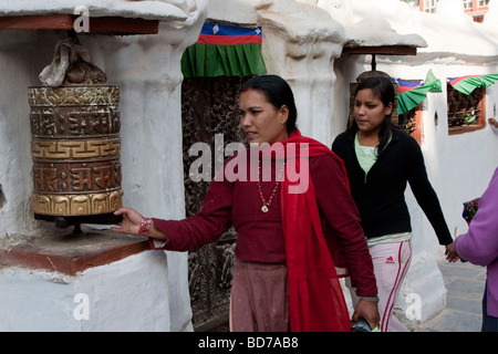 Bodhnath, Nepal.  Buddhist Worshiper Turning Prayer Wheel. Stock Photo