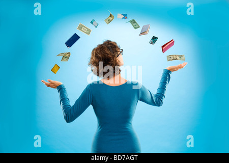 Woman juggling financial items Stock Photo