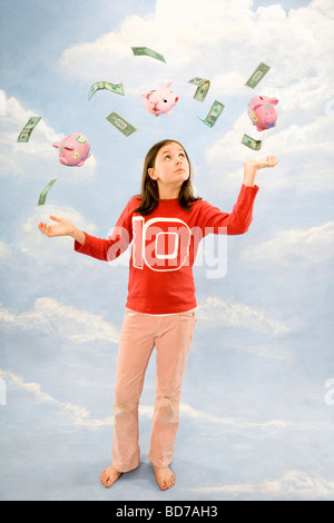 Girl juggling money Stock Photo
