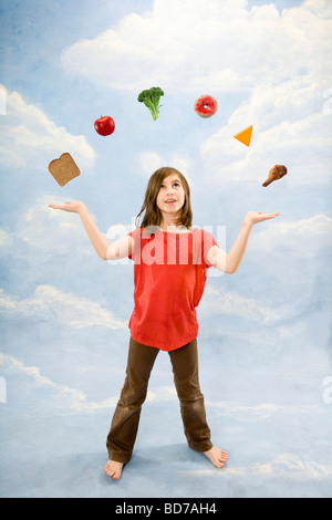 Child juggling different foods Stock Photo