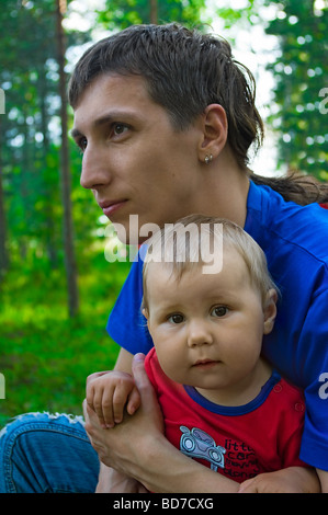 Young father and year-old baby on his hands. Half-length portrait. Stock Photo