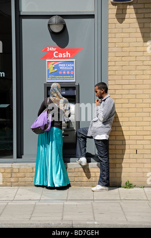 Couple at cash machine Holloway London England UK Stock Photo