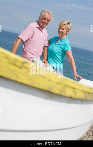 mature couple sitting on fishing boat at seaside Stock Photo