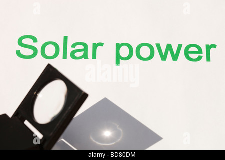 Solar power concentrating the suns power through a magnfying glass Stock Photo