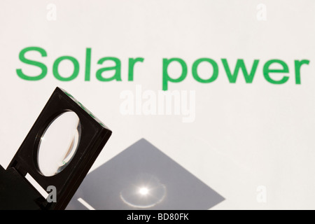 Solar power concentrating the suns power through a magnfying glass Stock Photo