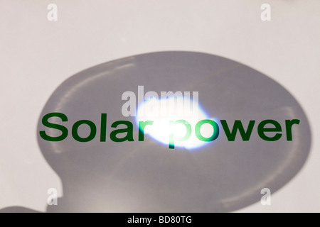 Solar power concentrating the suns power through a magnfying glass Stock Photo