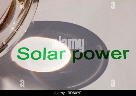 Solar power concentrating the suns power through a magnfying glass Stock Photo