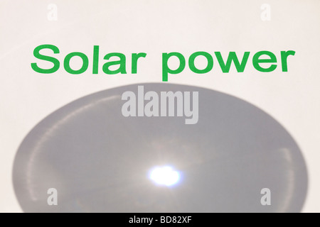 Solar power concentrating the suns power through a magnfying glass Stock Photo