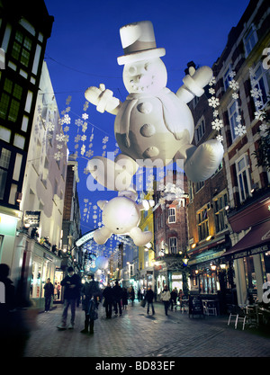 Christmas decorations, including giant inflatable snowmen, lit up at night in Carnaby Street, in London's West End. Stock Photo