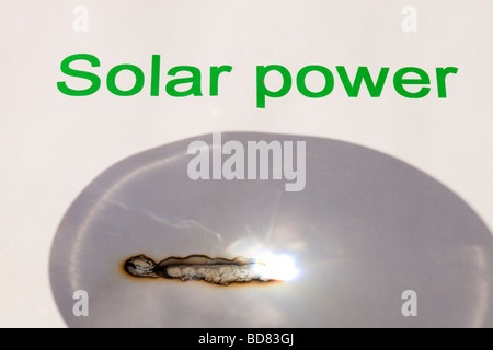 Solar power concentrating the suns power through a magnfying glass Stock Photo