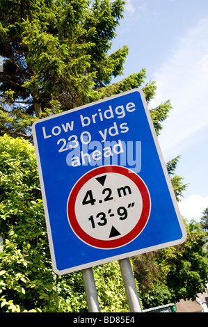 A sign indicates to oncoming traffic that there is a low bridge 230 yards ahead in england united kingdom Stock Photo