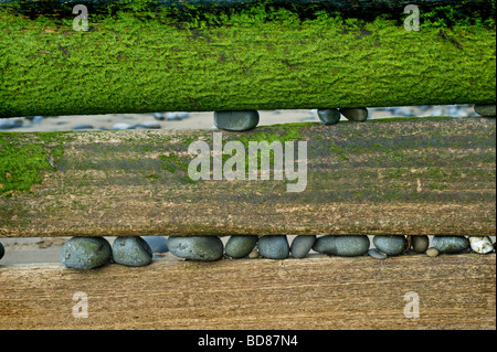 stones jams into the gaps of the wooden sea defences on the South Beach of Aberaeron Stock Photo