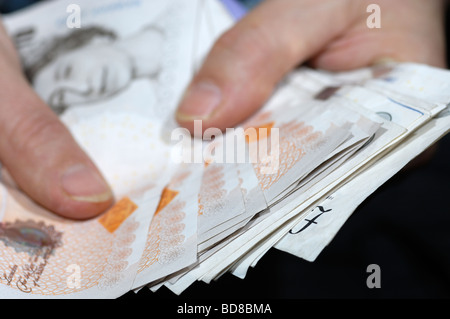 Hands holding a bundle of British sterling bank notes Stock Photo