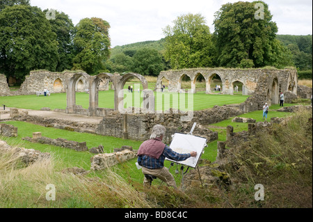 An artist paints the ruins of Hailes Abbey near Winchcombe in Gloucestershire. Stock Photo