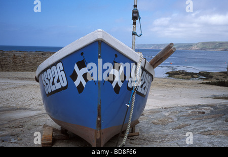 Small fishing boat showing the cornish flag in the harbour at Sennen Cove in Cornwall on the south west coast path Stock Photo