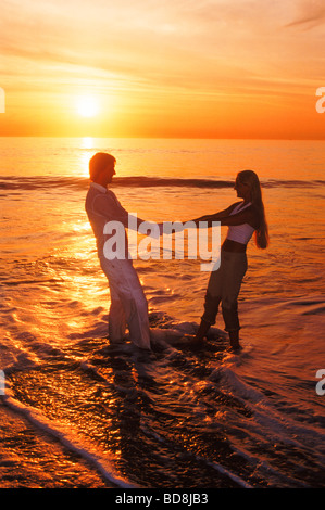 Couple playing on sandy shore at sunset in Laguna Beach California USA Stock Photo