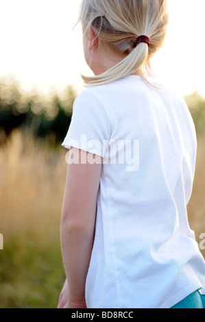 Royalty free photograph of a girl enjoying a summer evening camping in British national park and looking at sunset view. Stock Photo