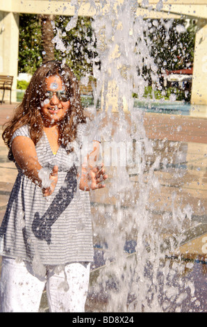 Girl plays in water fountain Stock Photo