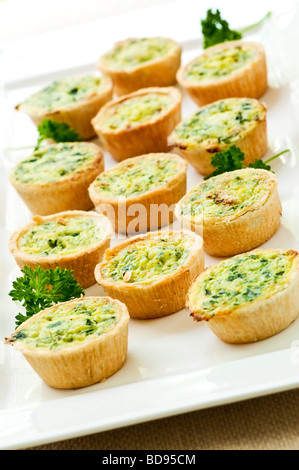 Plate of many mini bite size quiche appetizers Stock Photo