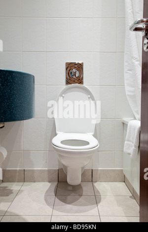 Toilet WC in a hotel bathroom lid up seat down Stock Photo