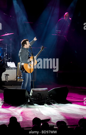 Jim Cuddy intoduces his band. Jim Cuddy of Blue Rodeo introduces his band at a cold outdoor concert. Stock Photo