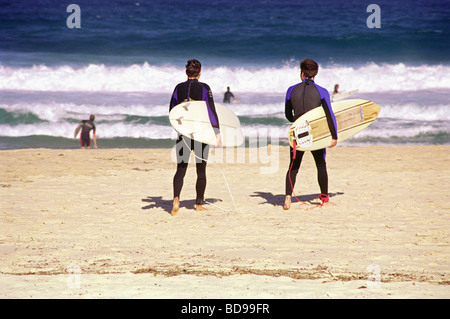 Two surfing buddies walking to the sea on Bondi beach Stock Photo