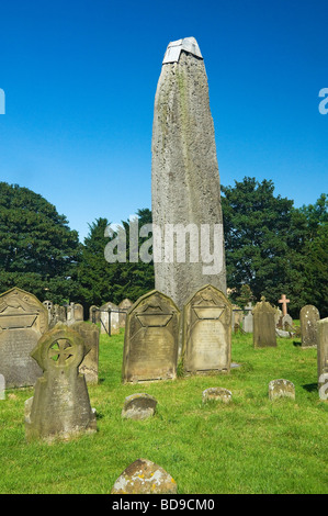 Rudston monolith and graves in the churchyard of All Saints Church in summer East Yorkshire England UK United Kingdom GB Great Britain Stock Photo