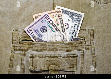 Three different US currency dollar notes in the pocket of a pair of khaki trousers Stock Photo
