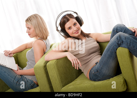 Two students sitting on armchairs and enjoying free time Stock Photo