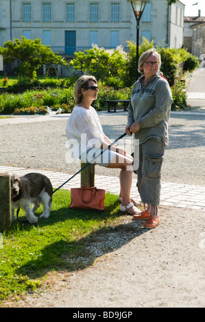 Two women with a dog in a garden Stock Photo - Alamy