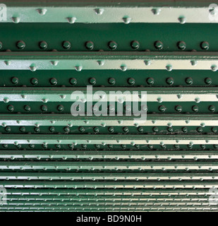 Lines of rivets in steel girders on underside of railway bridge over ...