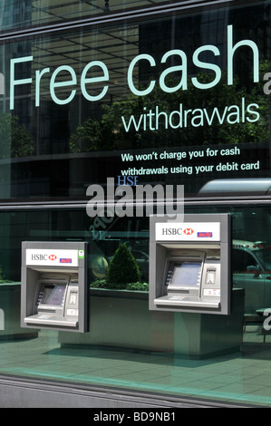 Free Cash slogan above atm cash machines also showing split height levels for disabled wheelchair users Stock Photo