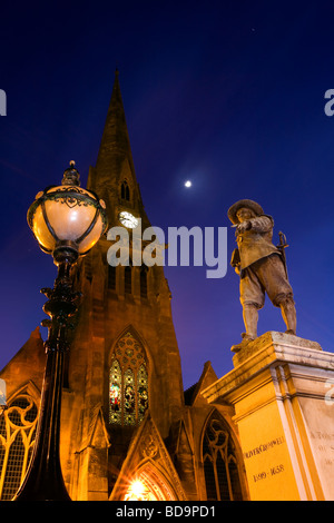 Statue of Oliver Cromwell in twilight juxtaposed with a street lamp and The Free Church in St Ives Stock Photo