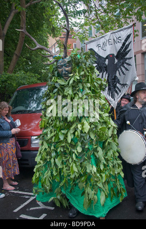 Pagans hold a Pagan Pride Parade in London in their Beltane Bash celebrations. Jack in the Green - Green Man - and Ravens banner Stock Photo