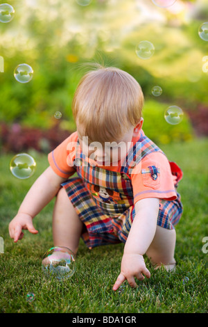 Portrait of a toddler playing with bubbles in the garden Stock Photo