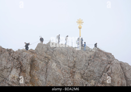 Hikers at the cross on the summit of Zugspitze Mountain, Alps Germany Stock Photo