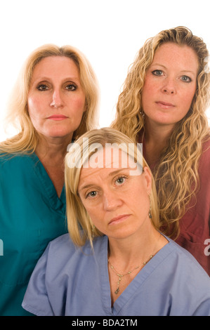 group of three pretty nurses or doctors or medical professionals wearing nurse s scrub clothes with serious expression on faces Stock Photo