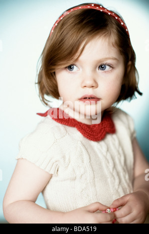 A pretty young girl wearing a white wool dress looking to the left Stock Photo