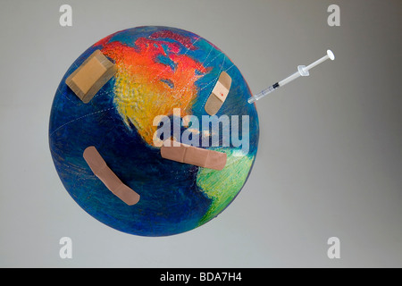 Still shot of a world globe with band aids and a syringe on the Oceans and Central America Stock Photo